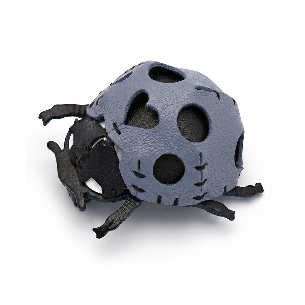 The Blue colourway — a ladybird model in pebbled leather with black head and legs, hand-stitched, with round cutouts.