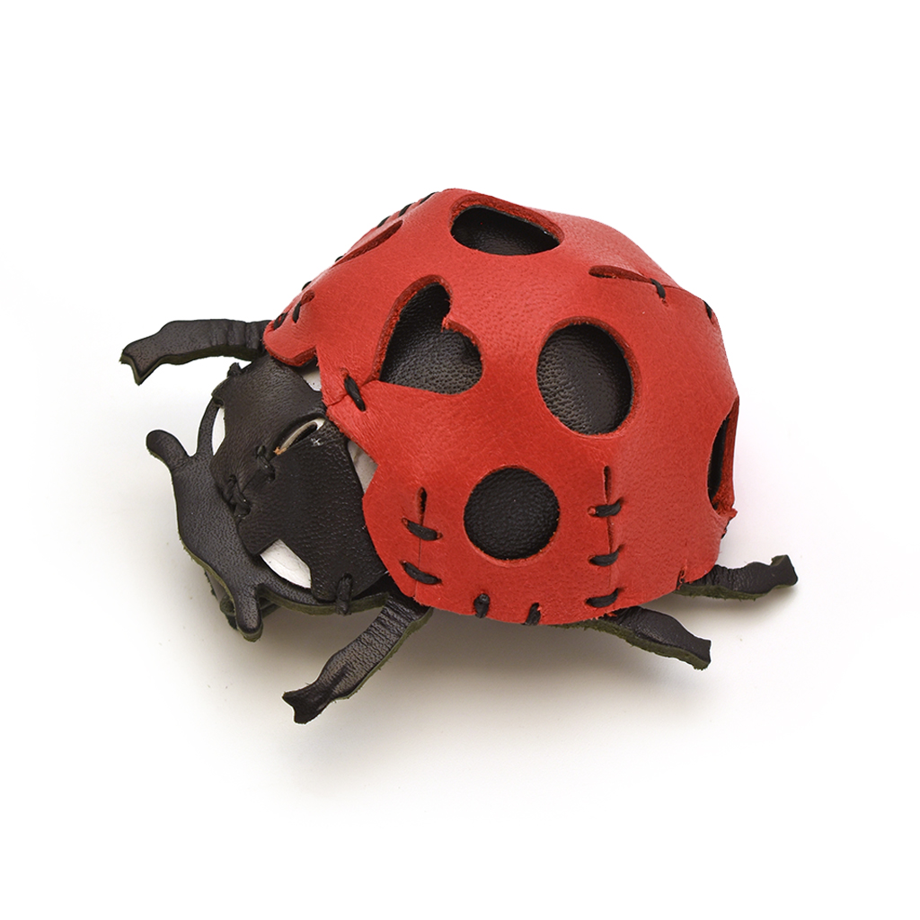 The Red colourway — a ladybird model in pebbled leather with black head and legs, hand-stitched, with round cutouts.